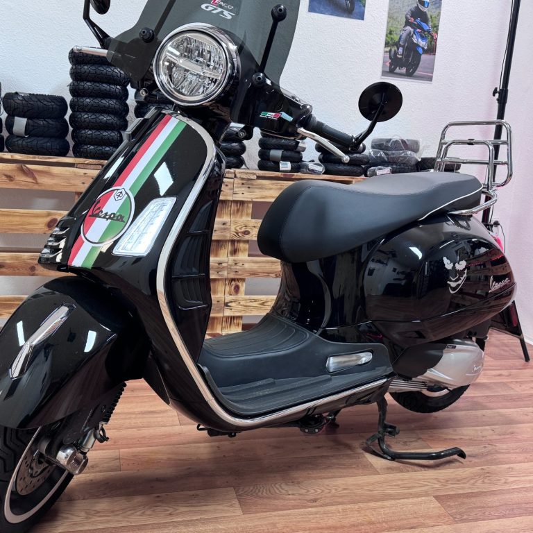 Schwarze Vespa mit italienischer Flagge, im Hintergrund eine Holzverkleidung.