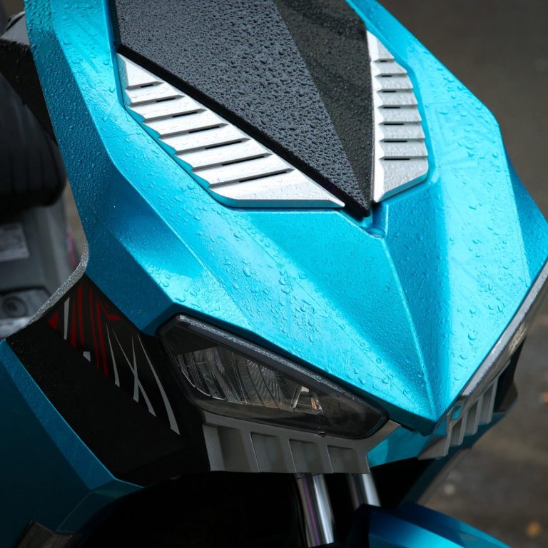 Blauer Roller mit stilvollem Design und feuchten Oberflächen durch Regen.